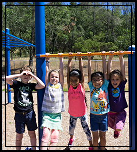 5 students hanging from the monkey bars