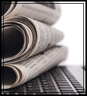 newspapers stacked on a computer