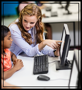 Teacher helping student with computer